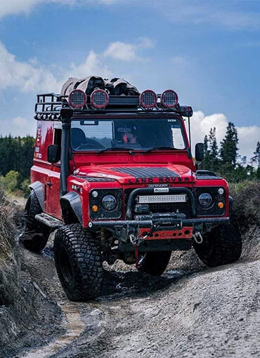 Land Rover driving over rock hill